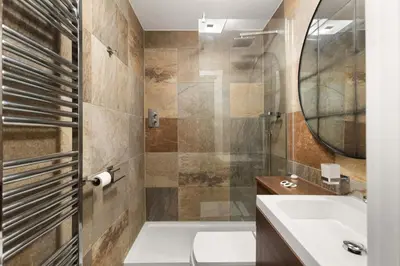 a bathroom with a sink and a toilet and a mirror at Modern 3BR Basement Flat with Outdoor Terrace in Southend-on-Sea