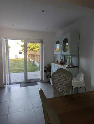 a dining room with a table and chairs and a sliding glass door at Walton holiday home in Walton-on-the-Naze