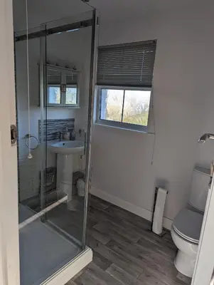 a bathroom with a shower and a toilet and a sink at Walton holiday home in Walton-on-the-Naze