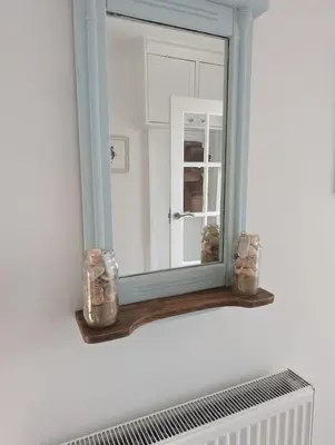 a mirror sitting on a shelf in a bathroom at Walton holiday home in Walton-on-the-Naze