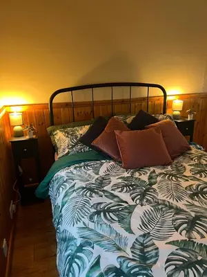 a bed with pillows on it in a bedroom at Readers Cabin-Cosy Countryside Studio Cabin in Great Sampford