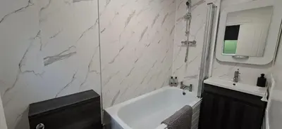 a white bathroom with a tub and a sink at Comfy 1 bed in the idyllic village of Hemingford Grey in Hemingford Grey