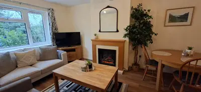a living room with a couch and a fireplace at Comfy 1 bed in the idyllic village of Hemingford Grey in Hemingford Grey