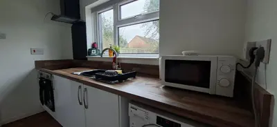 a kitchen with a counter with a microwave and a window at Comfy 1 bed in the idyllic village of Hemingford Grey in Hemingford Grey