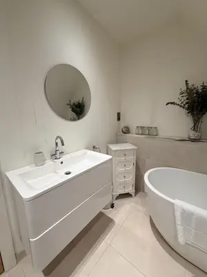 a bathroom with a sink and a tub and a mirror at Turnpike Red Lodge in Bury Saint Edmunds