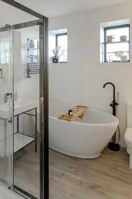 a white bath tub in a bathroom with a sink at Luxurious Retreat with Cinema Lounge in Ely