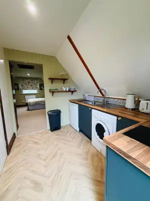 a kitchen with a washer and dryer in a room at The Barn at Catley Cross House in Little Maplestead