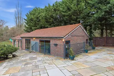 a brick building with a fence on a patio at Luxury 5 Bedroom with Pool & Games Room in Potter Street