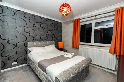 a bedroom with a bed and a couch at Luxury 5 Bedroom with Pool & Games Room in Potter Street