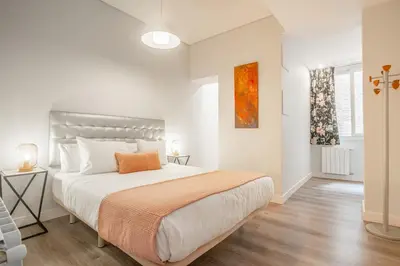 a white bedroom with a large bed and a window at Apartment Clarke in Cambridge