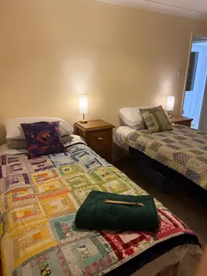 a bedroom with two beds and a green purse on a bed at The Wright 1 bedroom place to stay large drive in East Harling