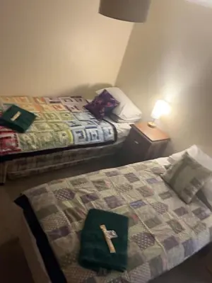 a cross sitting on top of a bed in a room at The Wright 1 bedroom place to stay large drive in East Harling