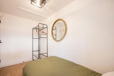 a bedroom with a bed and a mirror on the wall at Pink Cottage, Leiston in Leiston