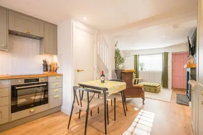 a kitchen with a table with a bottle of wine on it at Pink Cottage, Leiston in Leiston