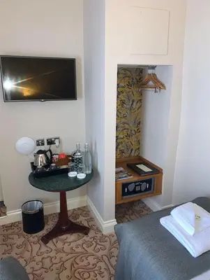 a room with a bed and a table with a television at Colchester Boutique Hotel in Colchester