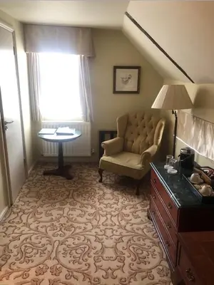 a living room with a chair and a table at Colchester Boutique Hotel in Colchester