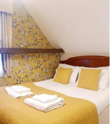 a bedroom with a bed with towels on it at Colchester Boutique Hotel in Colchester