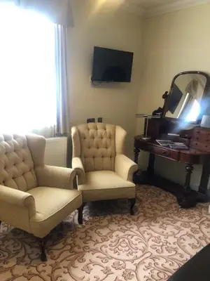 a living room with two chairs and a mirror at Colchester Boutique Hotel in Colchester