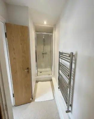a bathroom with a walk in shower and a door at The Jolly Brewers in Bishops Stortford