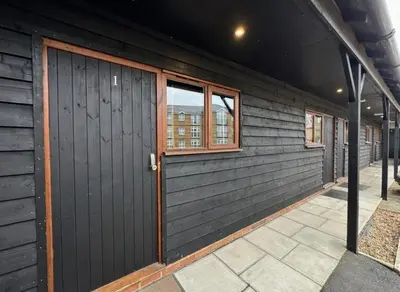 a wooden building with a door and windows at The Jolly Brewers in Bishops Stortford