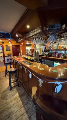 a bar with a wooden counter in a restaurant at The Jolly Brewers in Bishops Stortford