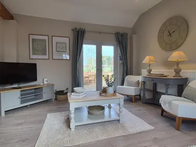 a living room with a couch and a tv at The Studio at Chequers - Newly Renovated Luxury Studio in Brome
