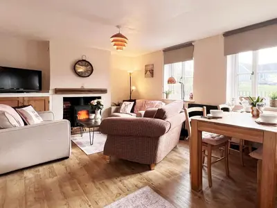 a living room with a couch and a table at Columbine Cottage by The Suffolk Cottage Collection in Middleton