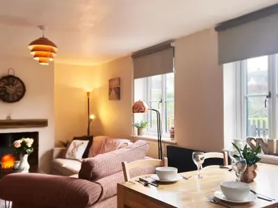 a living room with a table and a couch at Columbine Cottage by The Suffolk Cottage Collection in Middleton