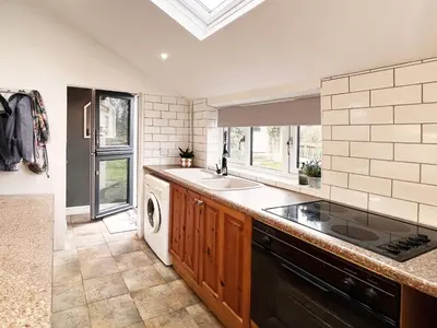 a kitchen with a sink and a dishwasher at Columbine Cottage by The Suffolk Cottage Collection in Middleton
