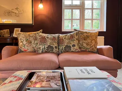 a couch in a living room with a table at Peak Hill Cottage in Theberton