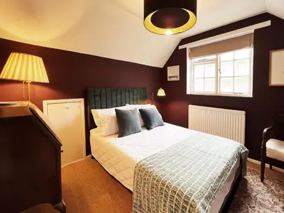 a bedroom with a bed and a window at Peak Hill Cottage in Theberton