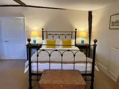 a bedroom with a bed with yellow pillows and two lamps at Quiet getaway for 2 near Bury St Edmunds in Honington