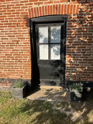 a door in the side of a brick building at Quiet getaway for 2 near Bury St Edmunds in Honington