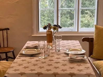 a table with plates and glasses and a vase on it at Quiet getaway for 2 near Bury St Edmunds in Honington