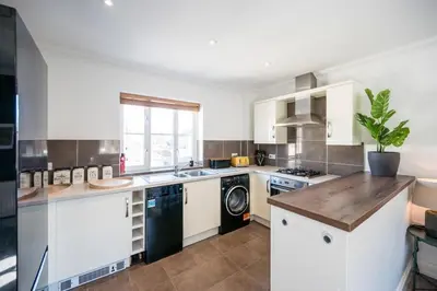 a kitchen with white cabinets and a dishwasher at Superb 2BR 2Bath with parking in Saxmundham