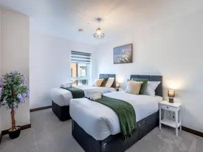 two beds in a room with white walls at Cosy 2-Bed Next to Harlow Town in Harlow