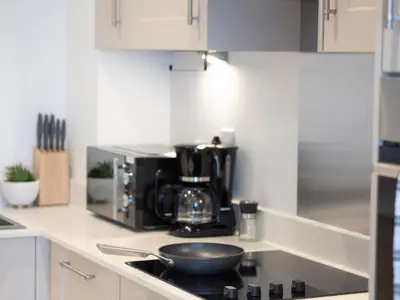 a kitchen with a microwave and a frying pan on a stove at Cosy 2-Bed Next to Harlow Town in Harlow