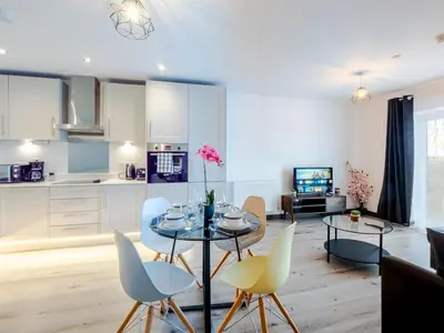 a kitchen and living room with a table and chairs at Cosy 2-Bed Next to Harlow Town in Harlow