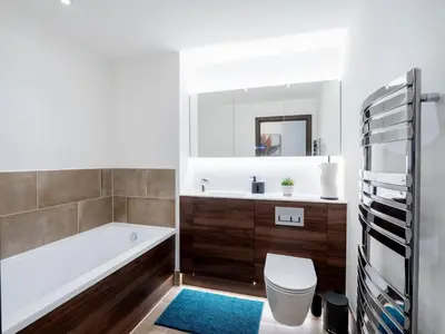 a bathroom with a tub and a toilet and a sink at Cosy 2-Bed Next to Harlow Town in Harlow