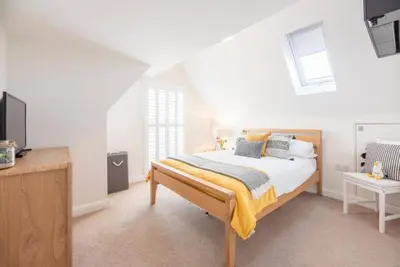 a bedroom with a bed and a television in it at North Cottage, Aldeburgh in Aldeburgh