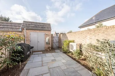 a brick house with a garage and a brick wall at North Cottage, Aldeburgh in Aldeburgh