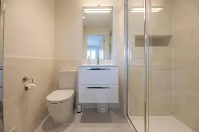 a white bathroom with a toilet and a shower at North Cottage, Aldeburgh in Aldeburgh