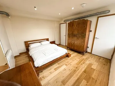 a bedroom with a bed and a wooden floor at Portman Business & Leisure Duplex in Ipswich
