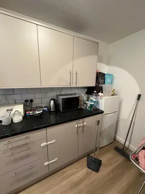 a kitchen with white cabinets and a black counter top at Aneliya home in Enfield