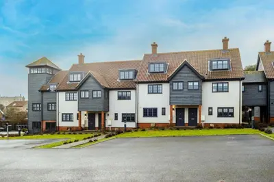 a large white house with black roof at 4 Oakes Court, Thorpeness - Sleeps 6 - Close to Thorpeness Meare and the beach, Close to Thorpeness Golf, Hotel and Country Club, Only 2 miles from #Aldeburgh, Managed by Aldeburgh Coastal Cottages in Thorpeness