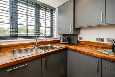 a kitchen with a sink and a wooden counter top at 4 Oakes Court, Thorpeness - Sleeps 6 - Close to Thorpeness Meare and the beach, Close to Thorpeness Golf, Hotel and Country Club, Only 2 miles from #Aldeburgh, Managed by Aldeburgh Coastal Cottages in Thorpeness