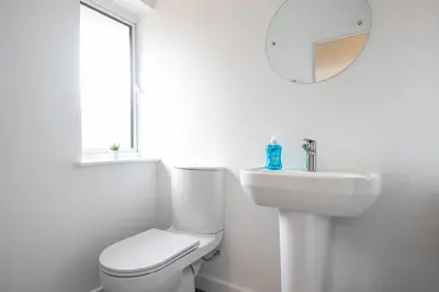a white bathroom with a toilet and a sink at Shrub End Lodge - Colchester in Lexden