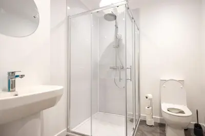 a white bathroom with a shower and a toilet at Shrub End Lodge - Colchester in Lexden