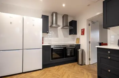 a kitchen with white appliances and black cabinets at Shrub End Lodge - Colchester in Lexden