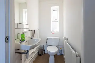 a white bathroom with a toilet and a sink at Sizewell - Lincoln - Contractor Accommodation in Saxmundham